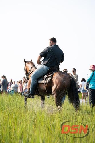 Saltwater Cowboy on horseback facing the crowd in the marsh.jpg