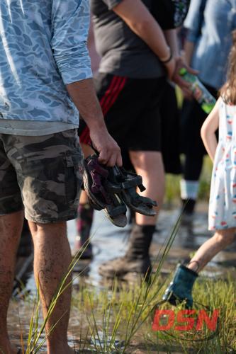 Man holding a pair of muddy sandals.jpg