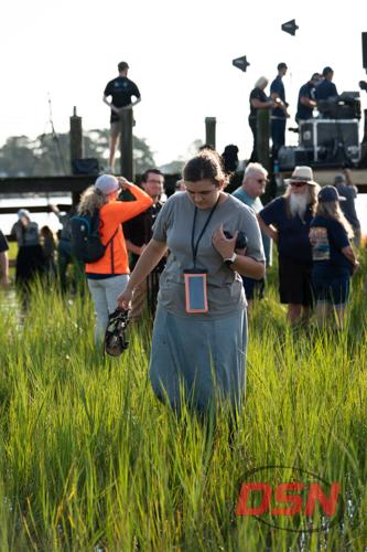 Woman carrying her sandals through the marsh.jpg