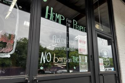 A storefront window painted with the words “Hemp for the people, protect all cannabinoids, no bans on THC."