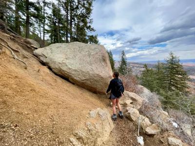 Chandler Boyd, 5-foot-7, stands beside a boulder that recently fell onto the middle of the Barr Trail, coming to rest on another rock outcropping. Photo: Spencer McKee.