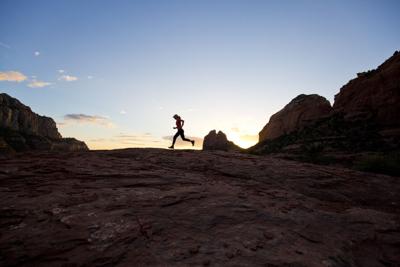 A woman goes for a cross-country trail run Photo Credit: GibsonPictures (iStock).