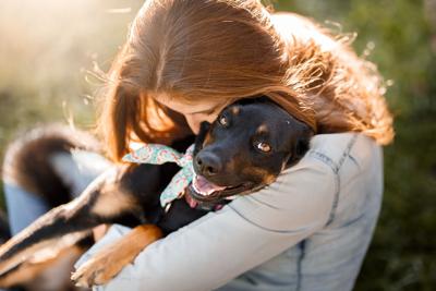 Girl hugging her dog Photo Credit: Capuski (iStock).
