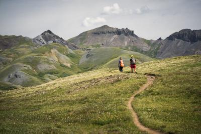 Two people enjoying a hike through the mountains on the Continental Divide Trail in San Juan National Forest. Photo Credit: wanderluster (iStock).