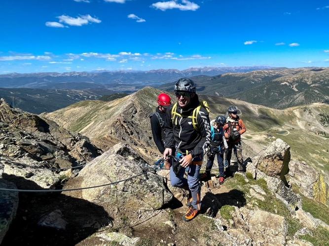 Eric Henderson tops out after scaling a vertical section of the Arapahoe Basin Via Ferrata. Photo Credit: Spencer McKee.