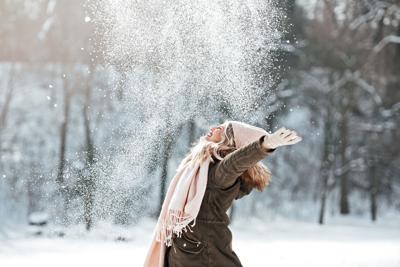 Beautiful young woman enjoying in the snow Photo Credit: Tijana87 (iStock).