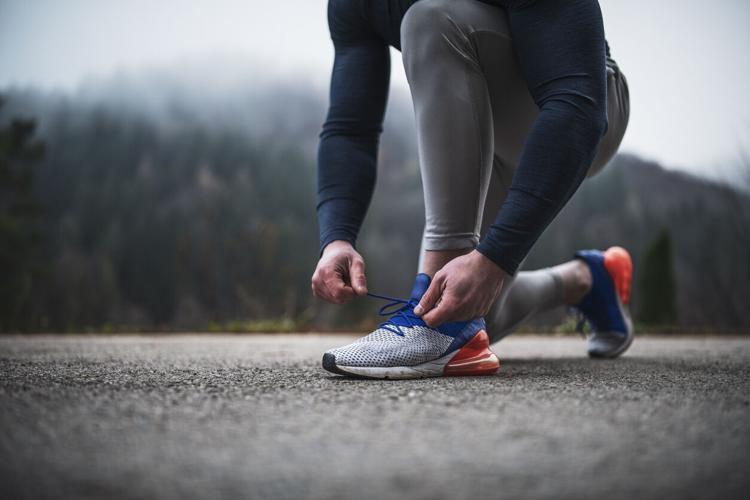 Athlete tying shoelace outdoor File photo. Photo Credit: ArtistGNDphotography (iStock).