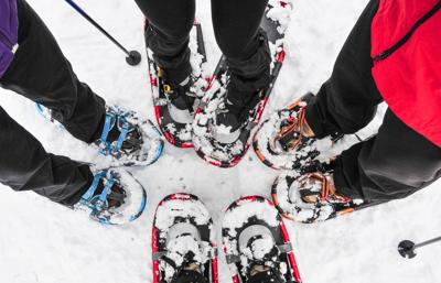 Four pairs of snowshoes on the snow Photo Credit: Debbie Galbraith (iStock).