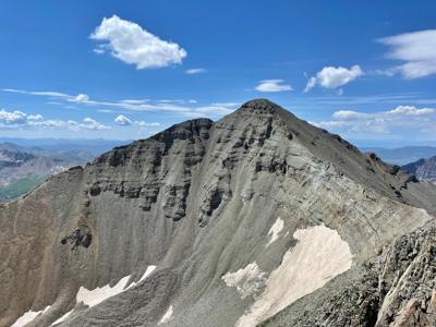 Castle Peak, as seen from the summit of Conundrum Peak. The standard route to the summit of Castle Peak can be seen as the faint trail along the ridge to the left of the image. The route between both peaks can be seen on the right side of the image. Pho...