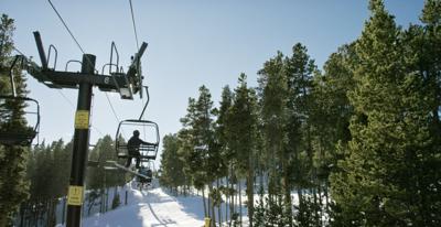 Snowboarders Ride a Ski Lift at Eldora Ski Resort near Boulder, Colorado on a Bright, Clear, Sunny Day