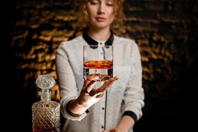bartender with whiskey Photo Credit: MaximFesenko (iStock).
