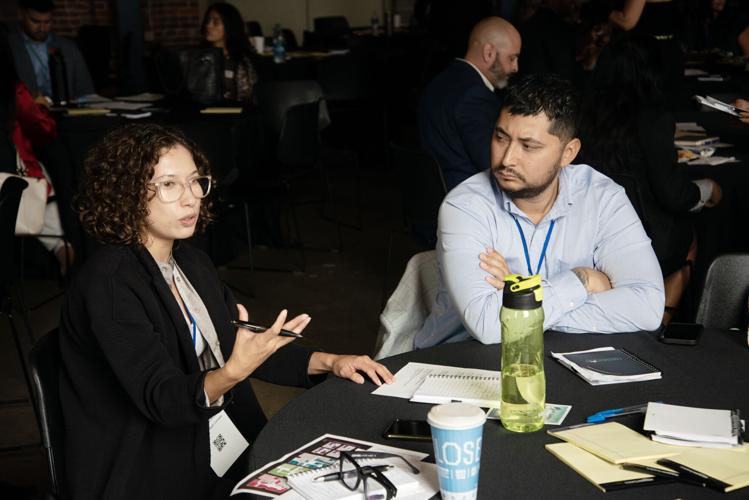 Briana Gonzales, left, and Antonio Rodriguez, right, speak with other attendees