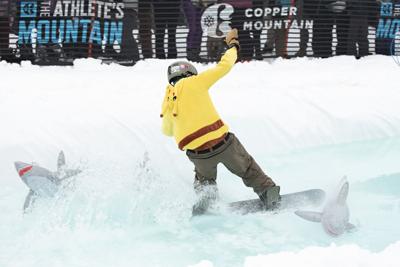 A snowboarder attempts to skim across Copper Mountain's Slush Rush