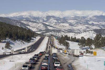 Traffic jam westbound I-70 highway with snow covered mountains Colorado