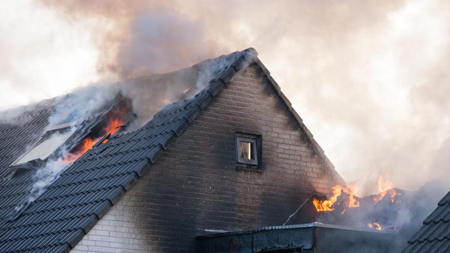 Fragment of a sooty white brick home that is on fire with flames Stock photo. Photo Credit: Jaap2 (iStock).