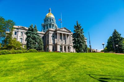 Colorado State Capitol building standing tall on green grass hill top
