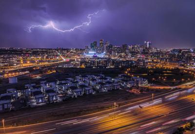 Beautiful cityscape of downtown Denver at nighttime with a long exposure of a lightning, Colorado