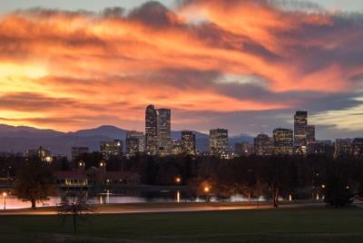 Denver Colorado skyline during sunset, with the Rocky Mountains visible in the background Photo Credit: Scott Heaney (iStock).