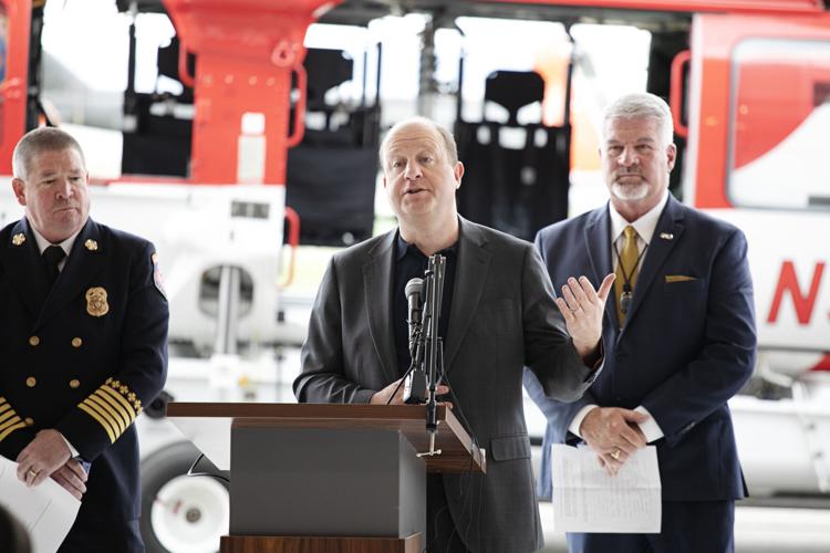 Gov. Jared Polis, center, gives remarks during Colorado's annual wildfire outlook