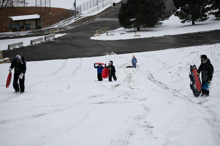 Sledders hike back up the sledding hill at Ruby Hill Park