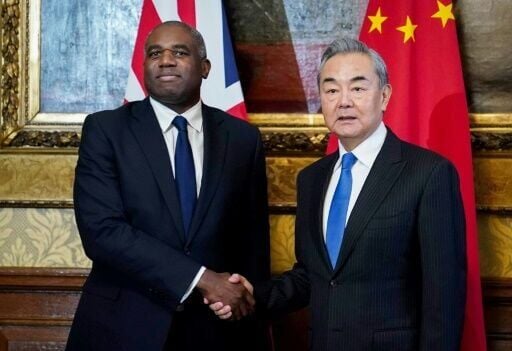 Britain's Foreign Secretary David Lammy (L) shakes hands with his Chinese counterpart Wang Yi ahead of a meeting at 1 Carlton Gardens in central London on February 13, 2025