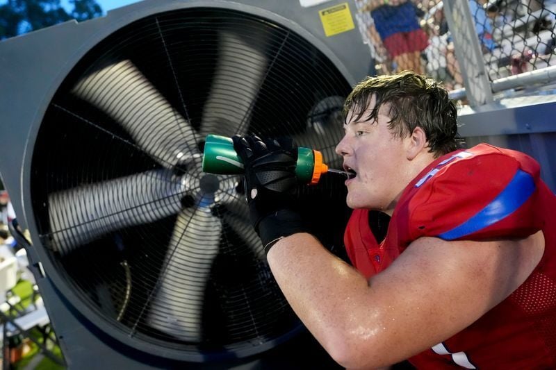 Athletes taking a cooling break during an intense Alabama football heatwave