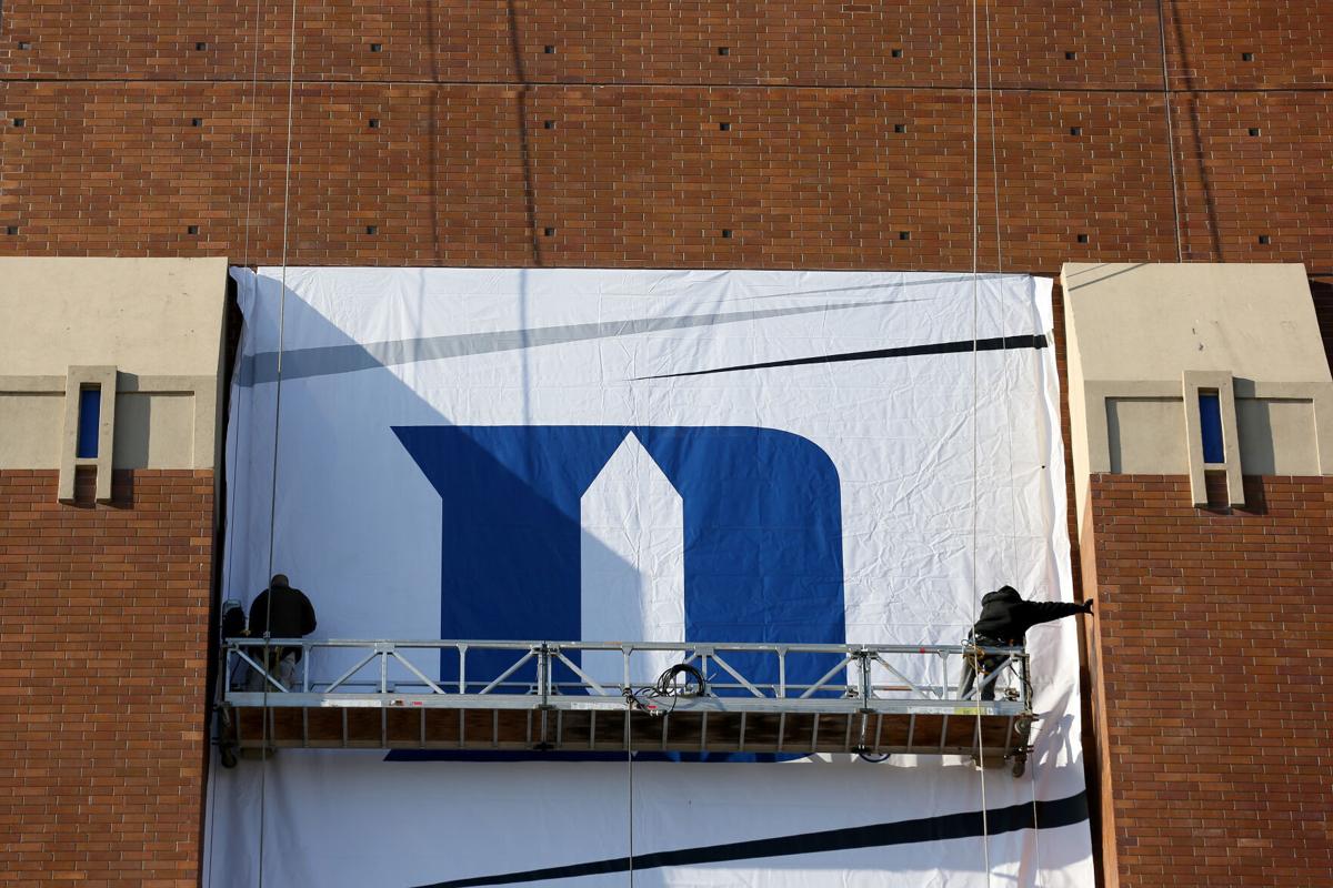 Workers hang the Duke Blue Devils logo on the side of Lucas Oil Stadium home of the 2015 Final Four on April 1, 2015 in Indianapolis, Indiana.