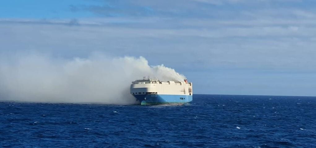 A cargo ship full of luxury cars is on fire and adrift in the