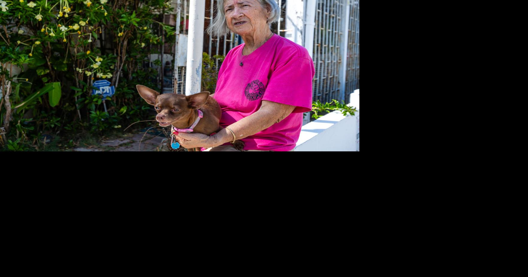 The tenant holding one of her dogs outside the house