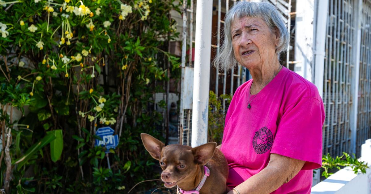 The tenant holding one of her dogs outside the house