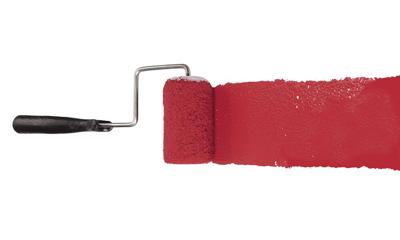 Paint roller with red pigment isolated over white background
