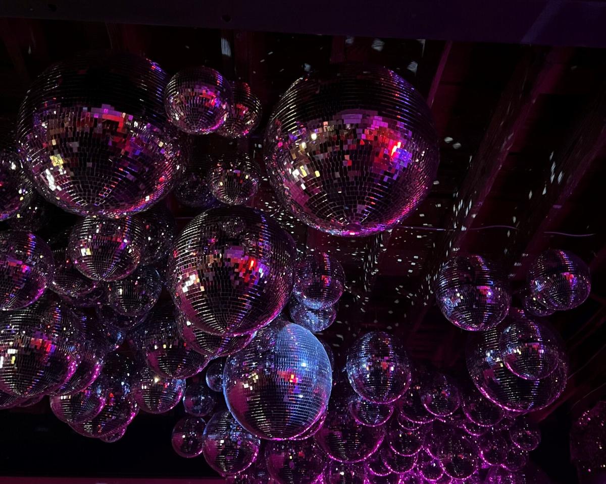 Wall Mural sparkling golden disco ball on a glowing purple background 