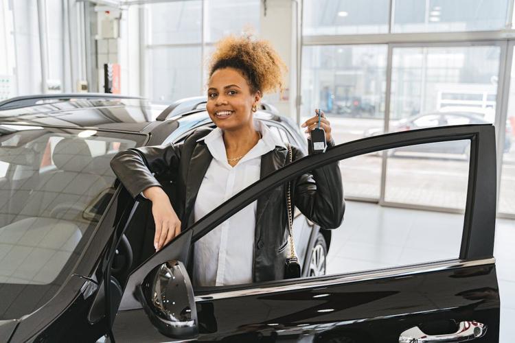 Woman poses next to her new car