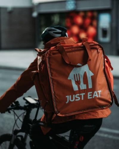 Delivery worker rides bike while delivering food