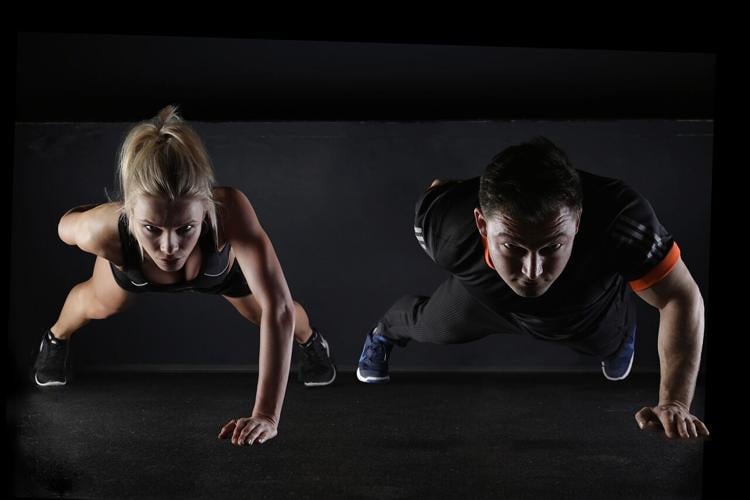 Two people do planks to improve their shoulder health