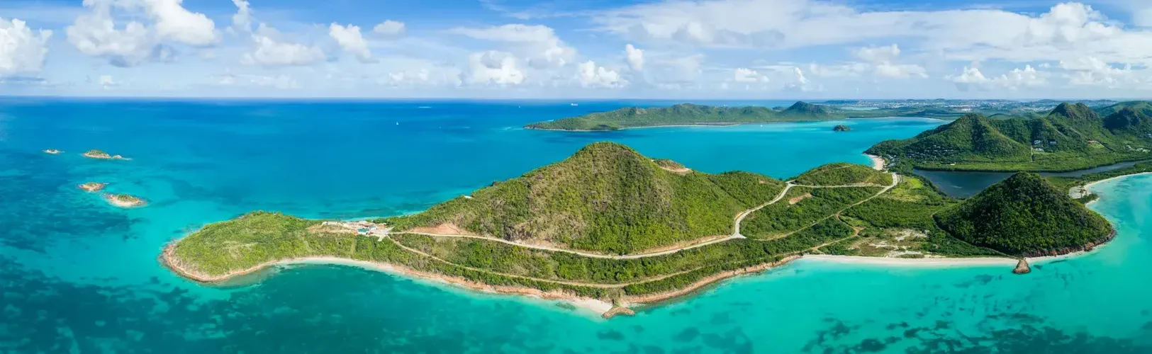 Wide aerial view of Pearns Point peninsula in Antigua surrounded by turquoise Caribbean water.