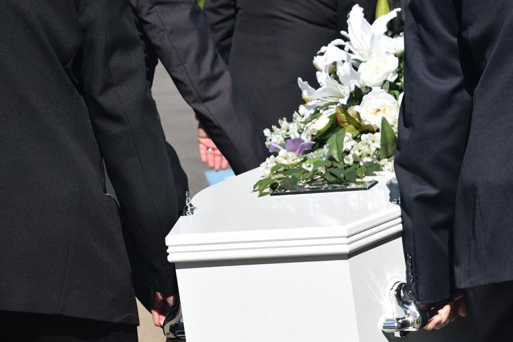 Casket carried by people during a funeral with pre-planned services
