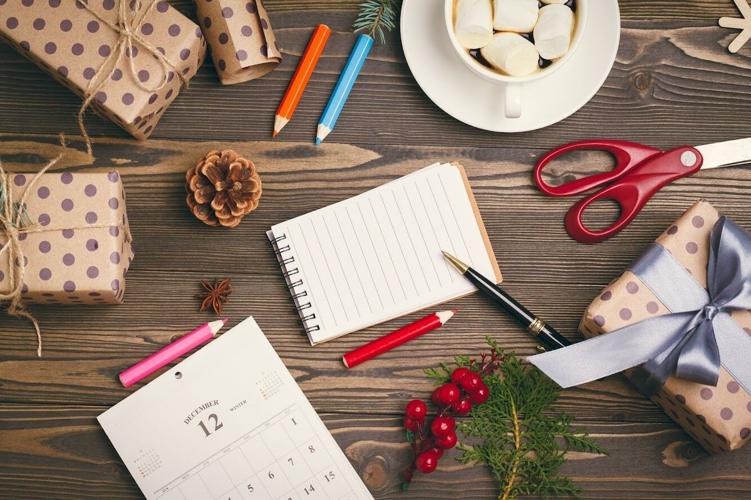 Christmas supplies laid out on table in preparation for making Christmas gift list