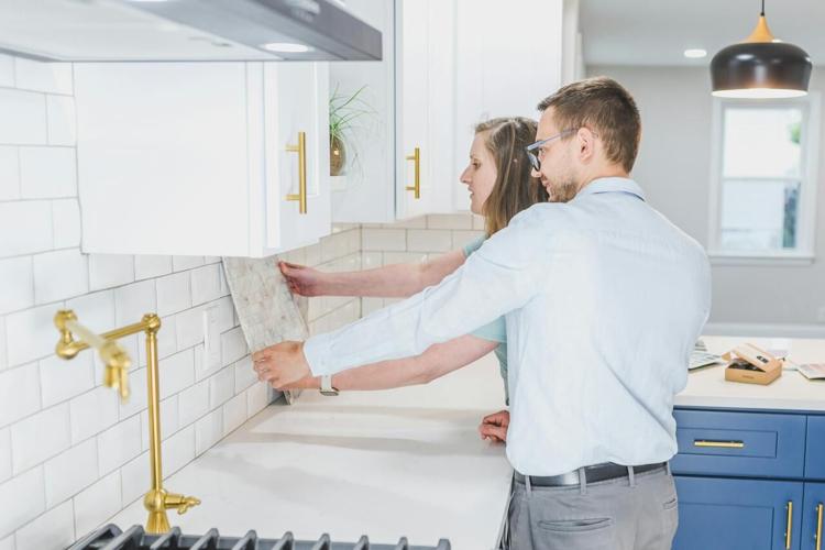 Man and woman compare tile options for their kitchen remodel