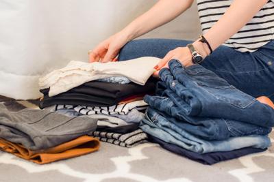 Woman folds clothes to donate as part of her decluttering process