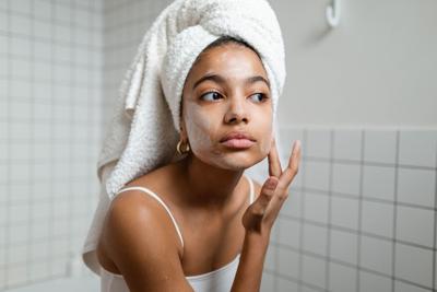 Woman applies multi-purpose cream to her face