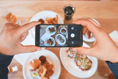 Person takes photo of food to post on online review website