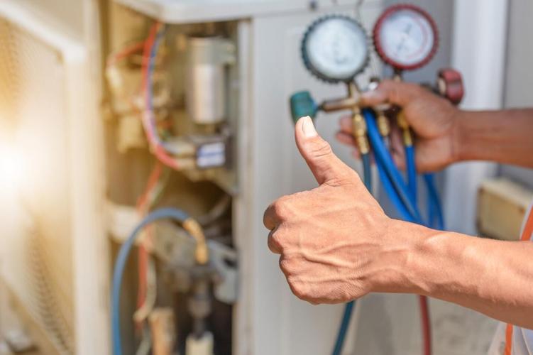 Man gives thumbs up after checking an AC unit's health status
