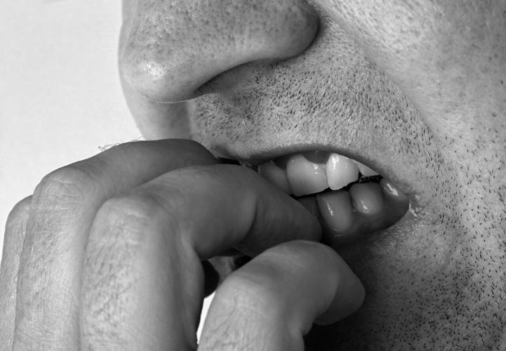 Man bites his nails out of habit or anxiety