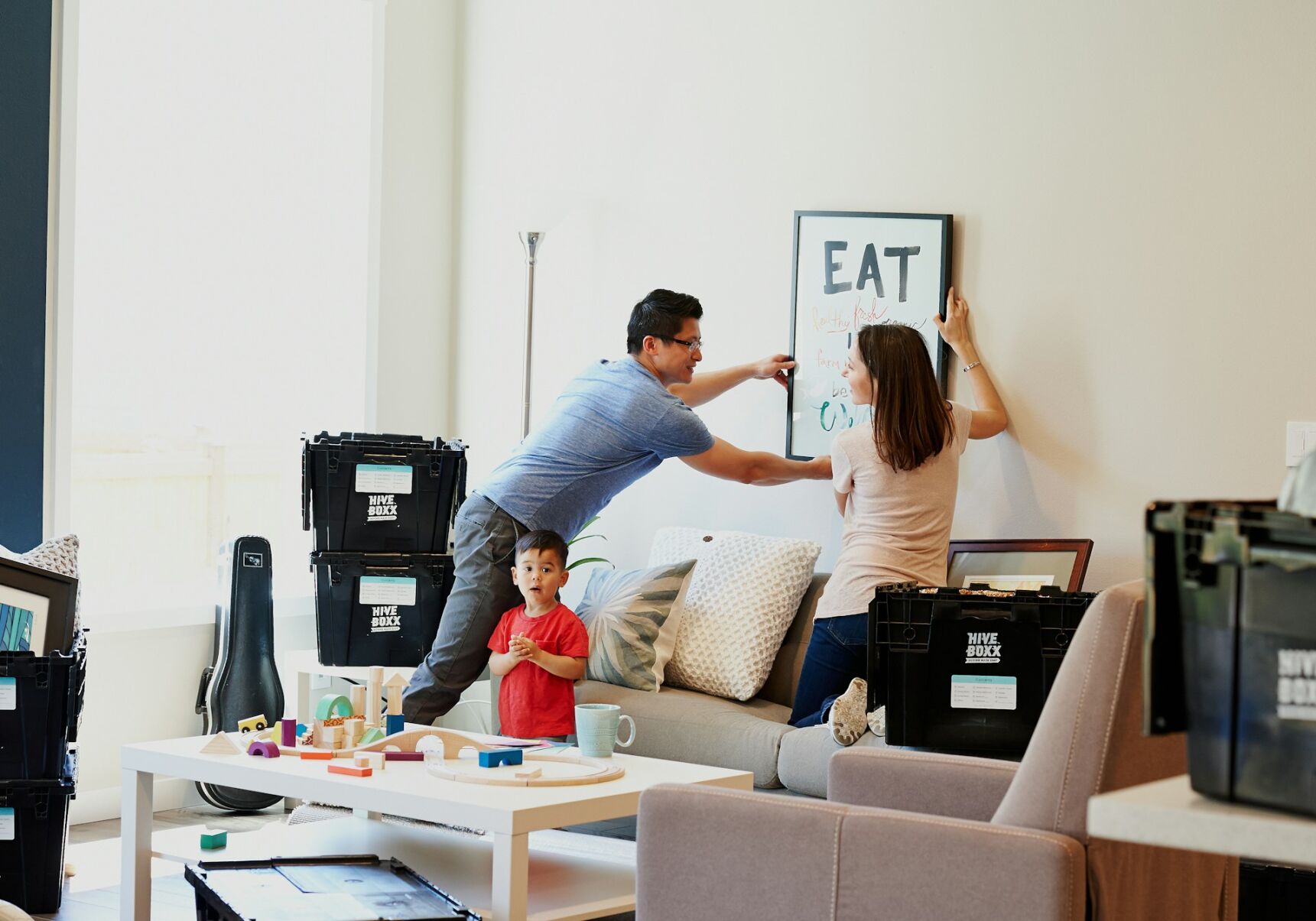 Couple removes painting from wall in preparation for a move