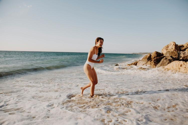 woman in white bikini standing on beach