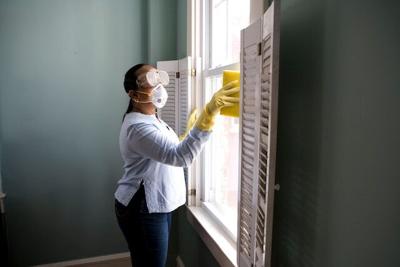 Woman cleans window sill as part of the pest control process