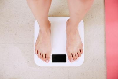 Person weights themself to check progress of their DNA diet