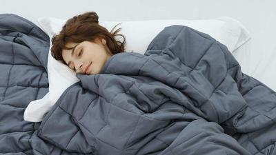 Women in bed with a gray everlasting comfort blanket throw