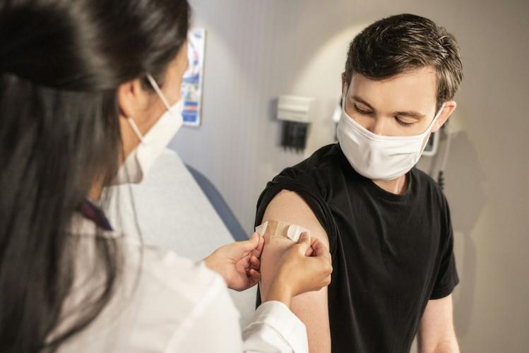 Doctor applies bandaid to persons arm after health treatment in Dubai